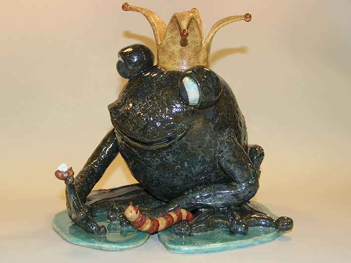 A ceramic frog with a crown on it's head.