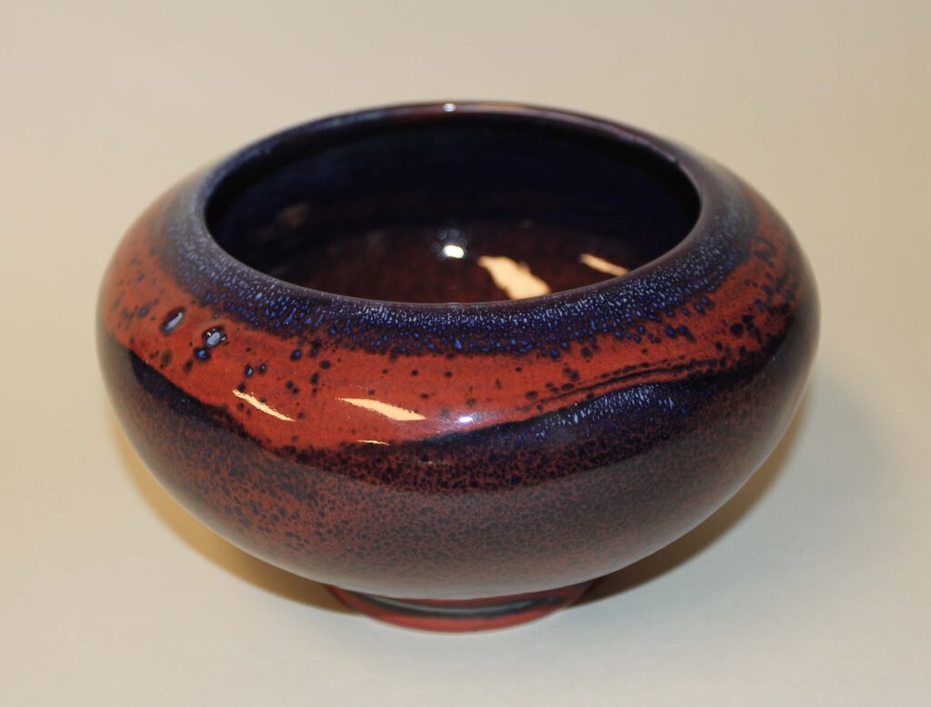 A bowl with red and blue design on it.