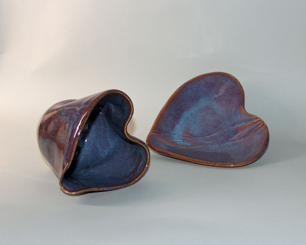 Two heart shaped bowls are sitting on a table.