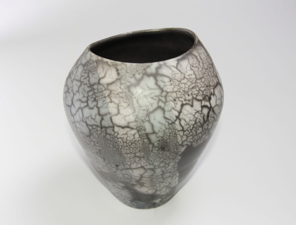 A black and white vase with cracked paint.