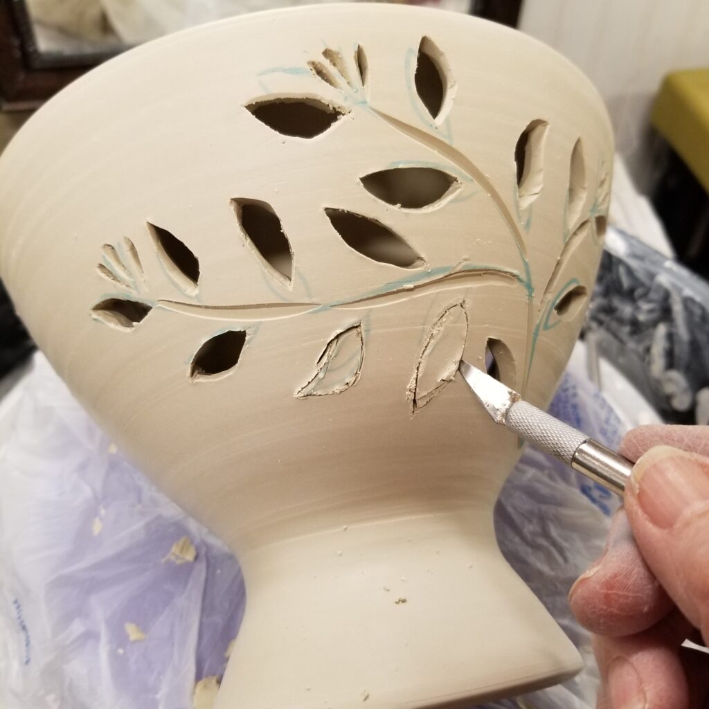 A person painting leaves on the side of a chair.