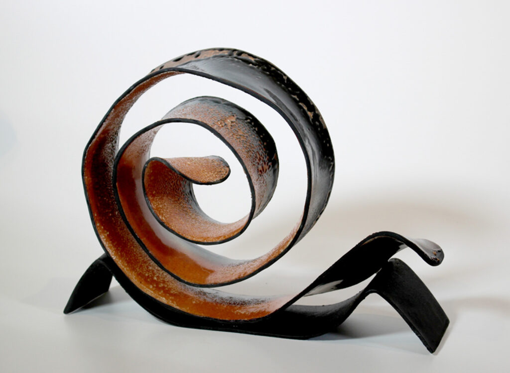 A sculpture of an abstract spiral sitting on top of a table.