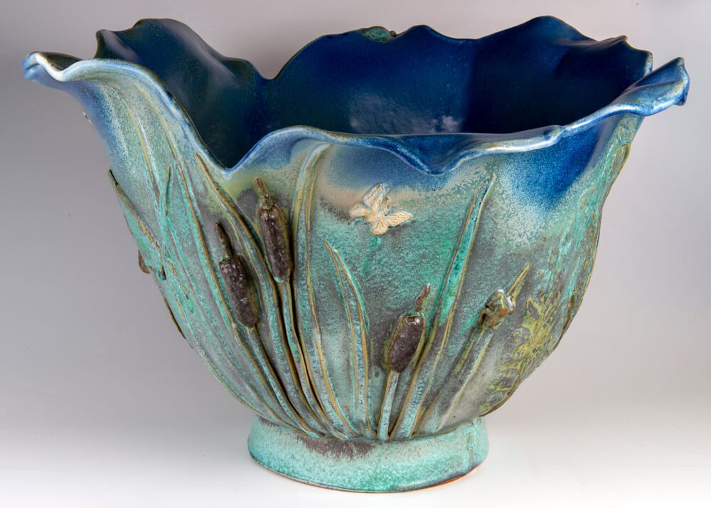 A blue bowl with a plant design on it.